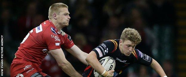 Angus O'Brien of Newport Gwent Dragons is tackled by Johnny Mcnicholl