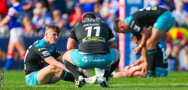 Leeds Rhinos players slumped on the turf after another loss