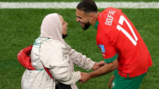 A close-up shot of Sofiane Boufal and his mother smiling at each other and holding hands