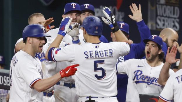 The Texas Rangers celebrate a home run by Corey Seager (centre)
