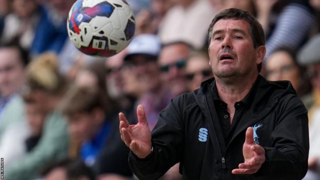 Mansfield boss Nigel Clough catches the ball on the sideline