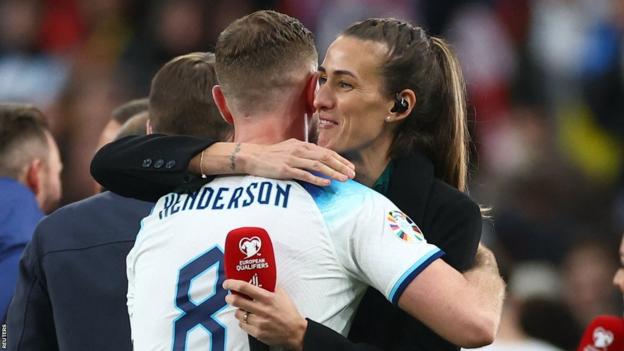 Jordan Henderson de Inglaterra celebra con la ex jugadora y experta en televisión Jill Scott