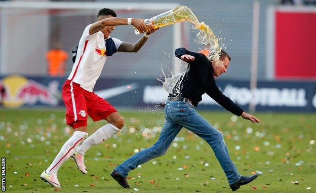 Rangnick, pictured celebrating RB Leipzig's 2016 promotion to the Bundesliga, chased by a player pouring beer over his head
