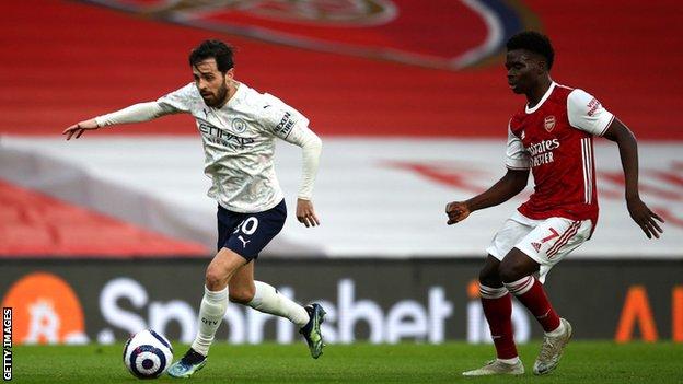 Bernardo Silva of Manchester City gets past Bukayo Saka of Arsenal on Sunday