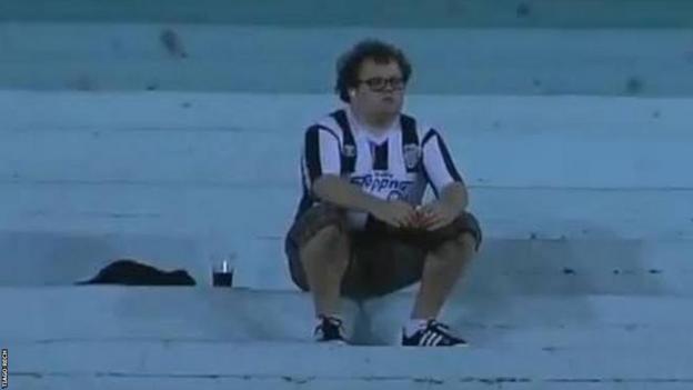 Tiago Rech sits alone watching FC Santa Cruz play Gremio in 2012