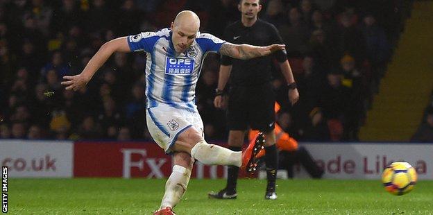 Huddersfield's Aaron Mooy takes a shot against Watford