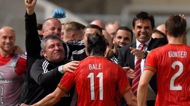 Gareth Bale celebrates with Wales' coaches