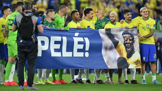 Brazilian soccer players hold a banner dedicated to Pele