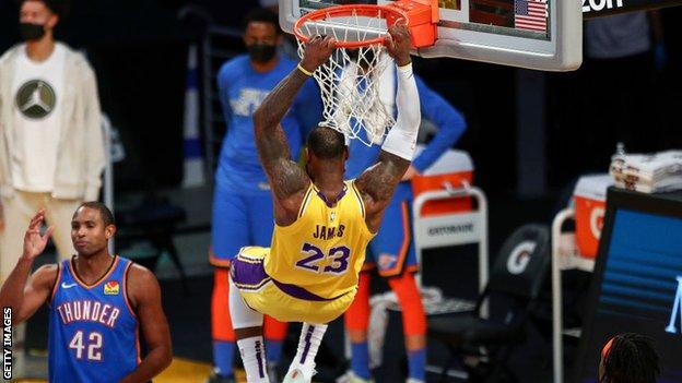 LeBron James hangs on the basket