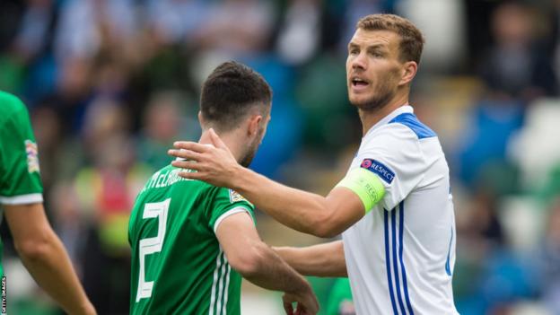 Edin Dzeko in action against Conor McLaughlin