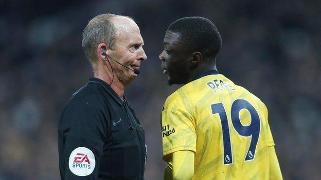 Mike Dean (left) and Arsenal's Nicolas Pepe