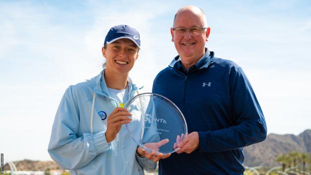 Steve Simon (right) presents Iga Swiatek (left) with the 2022 WTA Player of the Year award