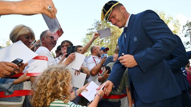 Owen Farrell signs an autograph for a young fan at the England team's welcome ceremony in Le Touquet
