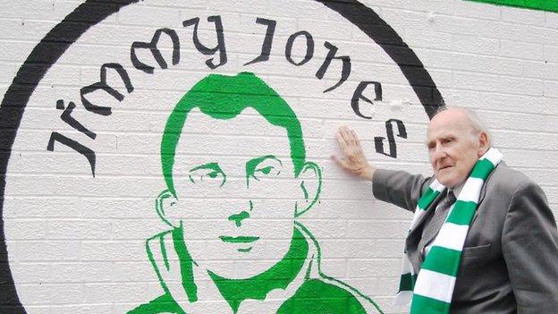 Jimmy Jones stands at a modern mural which immortalises his brilliant career at Belfast Celtic