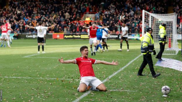 Jordan Davies celebrates his late winner against Salford City in front of the fans