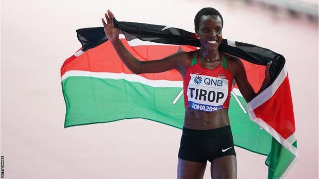 Kenya Agnes Jebet Tirop holding Kenyan flag after winning the bronze medal on the Women's 10,000m at the 2019 World Athletics Championships in Doha.
