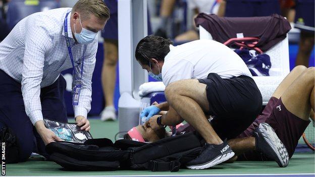 Rafael Nadal receives treatment after hitting himself on the nose with his own racket