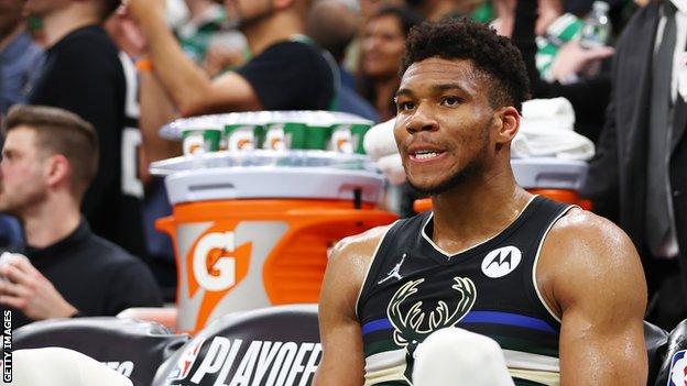 Milwaukee Bucks star Giannis Antetokounmpo watches from the bench during defeat by the Boston Celtics