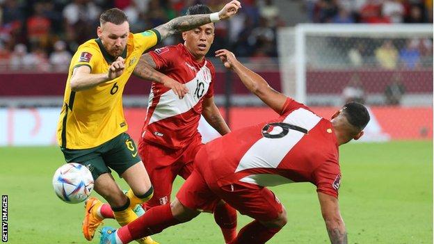 El davanter australià Martin Boyle és abordat pel defensa peruà Miguel Trauco durant el play-off de la Copa del Món 2022