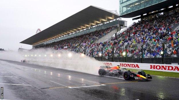 Verstappen's Red Bull continues to leave a cloud of spray in its wake after the Japanese Grand Prix is restarted