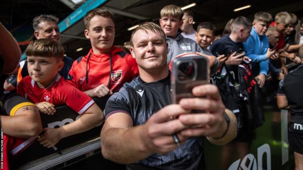 Wales hooker Dewi Lake takes pictures with fans at the open training session at the Principality Stadium