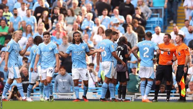 Fulham players argue with referee Michael Oliver