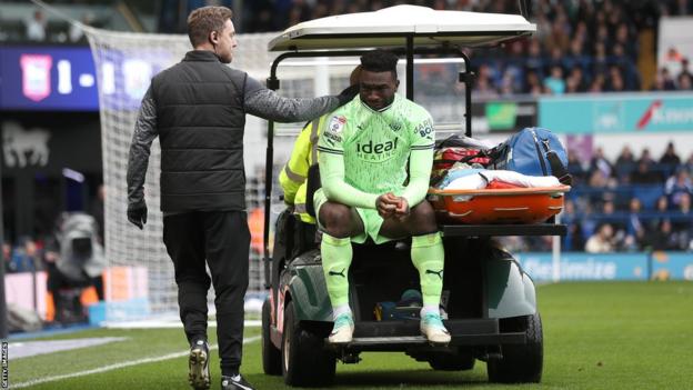 West Brom striker Daryl Dike being taken off the field on a golf cart after getting injured against Ipswich