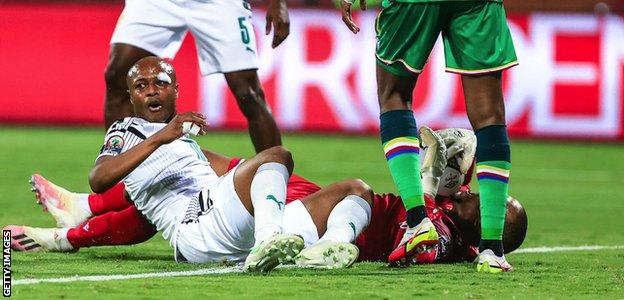 Andre Ayew clashes with the Comoros goalkeeper