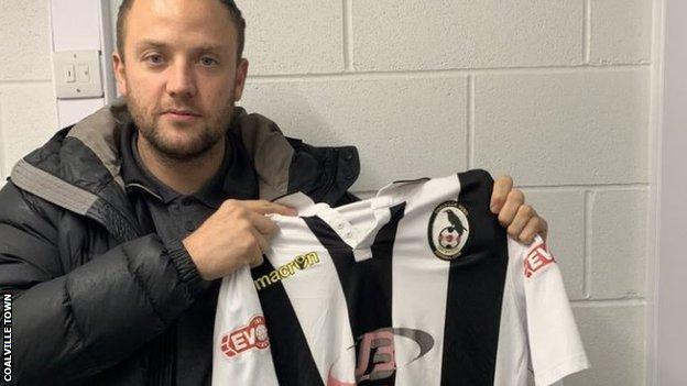 Kyle Perry holds up a Coalville Town shirt after signing for the non-league club