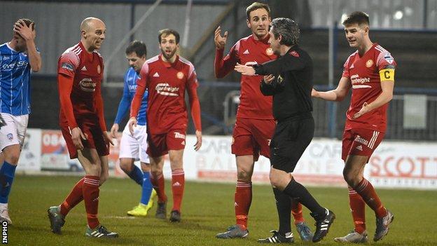 Greg Hall (left) was penalised for handball by referee Ross Dunlop