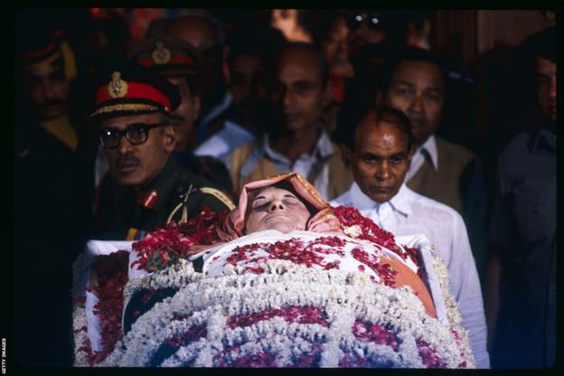 Indira Gandhi is carried in a casket covered in flowers after her assasination