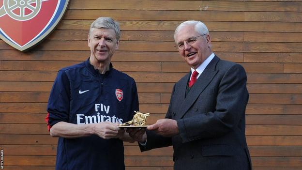 Sir Chips Keswick (right) presents Arsene Wenger (left) with a gold cannon to commemorate his 1000th game in charge of Arsenal