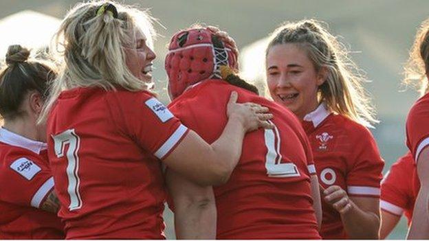 Wales players celebrate a try by hooker Carys Phillips