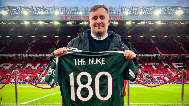 Darts player Luke Littler poses with a Manchester United shirt at Old Trafford