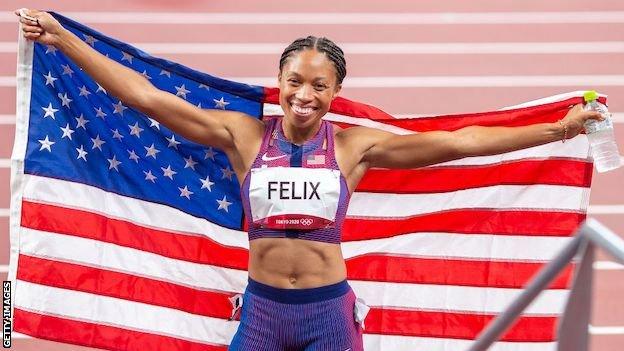 Allyson Felix holds the USA flag