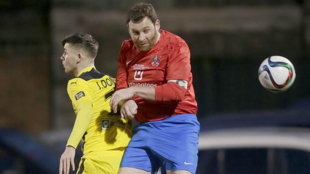 Jay Donnelly and Ards captain James Cully in action during the second domestic cup final of the season