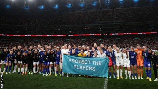 England and USA hold a banner reading 'Protect the players'