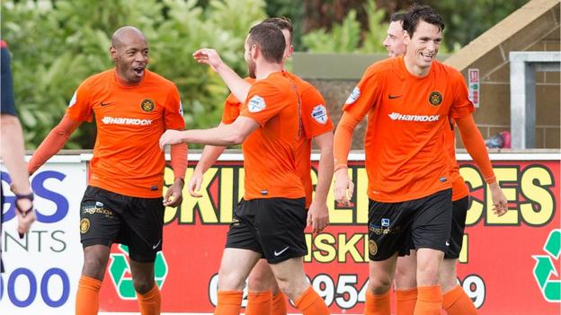 Carrick Rangers players congratulate Miguel Chines after the striker scored his goal in a 3-1 victory over Ballinamallard United