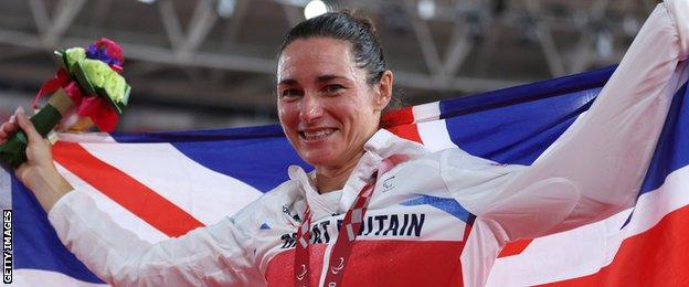 Sarah Storey holds aloft a Union flag to celebrate her individual pursuit gold medal at the Tokyo Paralympics