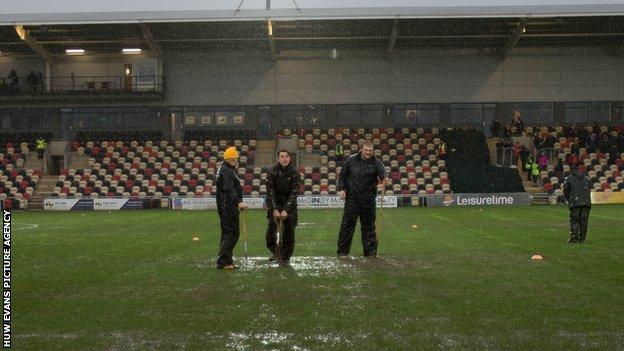 Ground staff work on the Rodney Parade pitch