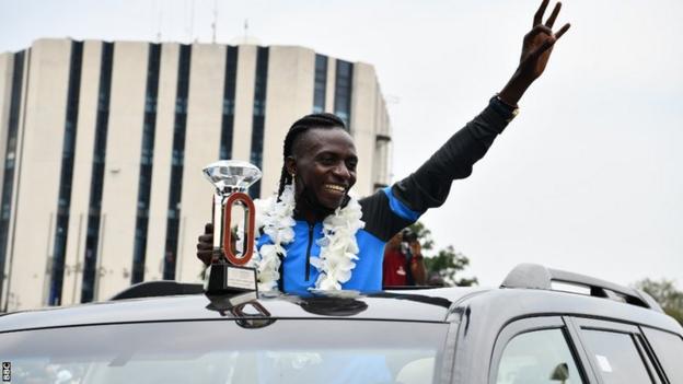 Athlete Francine Niyonsaba shows off her Diamond League trophy on her return to Burundi