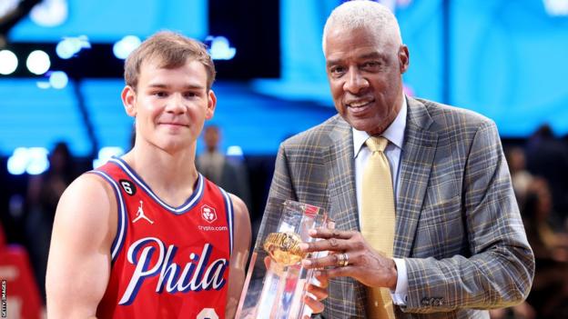 Mac McClung is presented with the slam dunk contest trophy by NBA legend Julius Erving