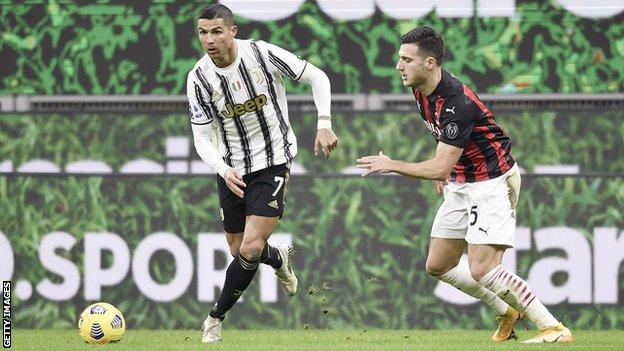 „Juventus“ puolėjas Cristiano Ronaldo (kairėje) vargsta pro „AC Milan“ žaidėją Diogo Dalotą (dešinėje)