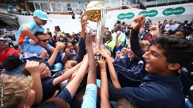 England captain Eoin Morgan is buried amid a sea of hands as he parades the World Cup trophy