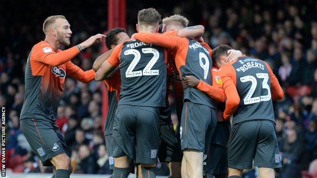 Swansea City players celebrate an own goal by Chris Mepham of Brentford