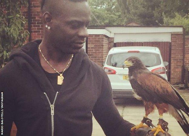 Mario Balotelli poses with a hawk