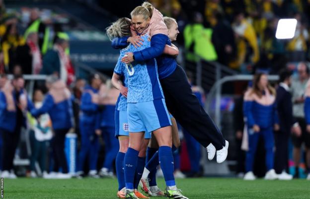 Sarina Wiegman is lifted up by Millie Bright