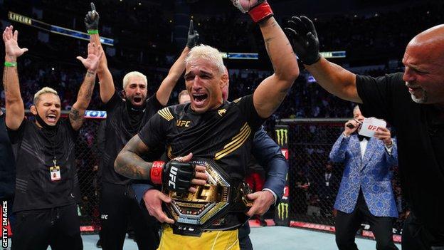 Charles Oliveira is awarded the lightweight championship belt after beating Michael Chandler at UFC 262
