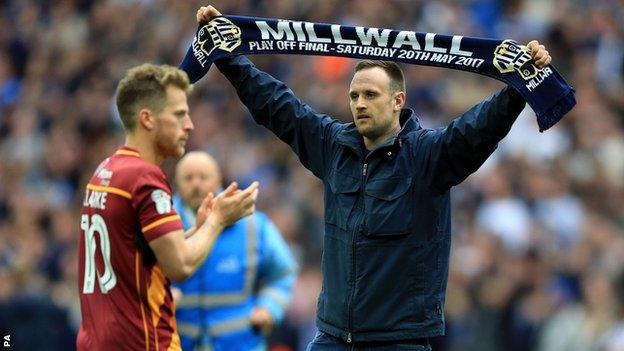 Millwall fans in front of a Bradford player