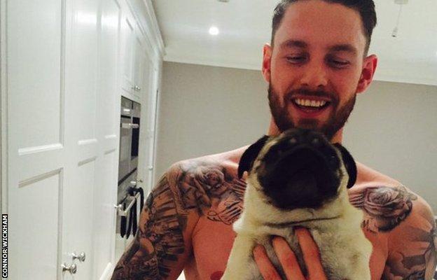 Crystal Palace striker Connor Wickham holding a dog